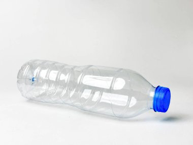 Mavi başlıklı boş, temiz plastik şişe geri dönüşüme hazır. Atık azaltma için çevresel uygulamalar sergileniyor. Su tasarrufu ve eko için sürdürülebilir bir gelecek teşvik ediliyor.