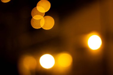 Bu büyüleyici görüntü, sıcak sarı ve altın renkli bulanık bokeh ışıklarının büyüleyici bir görüntüsünü sergiliyor, soyut ve rüya gibi bir arka plan yaratıyor, şenlik vesilesi için mükemmel. Yumuşak parıltı