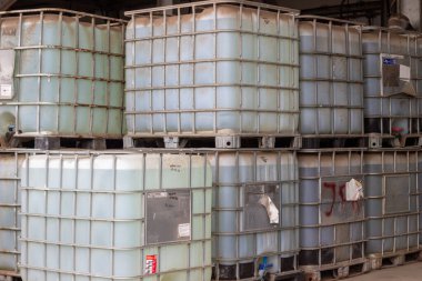 Bu resim paletlerin üzerine istiflenmiş endüstriyel konteynır (IBC) koleksiyonunu gösteriyor. Bu konteynırlar çeşitli sıvıların güvenli ve verimli bir şekilde depolanması ve taşınması için gereklidir.