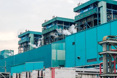 Bir endüstriyel üretim tesisinin kapsamlı bir dış görüntüsü, görünür enerji üretimi ve üretim süreçleriyle operasyonel becerilerini ortaya koyuyor. Bu tesis bir...