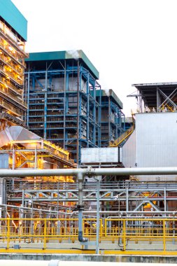 Bu görüntü modern endüstriyel mimarinin özünü yakalar, karmaşık bir çelik yapı ve boru sistemi sergiler. Fabrika ayarları mühendislik ve teknolojinin etkileşimini vurguluyor.,