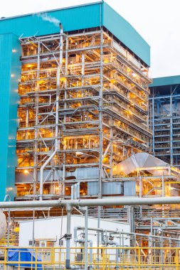 Bu fotoğraf endüstriyel maharetin özünü yakalar ve gece vakti yapay ışıkla yıkanan yüksek bir altyapı kompleksini gösterir. Çelik ve borulardan oluşan karmaşık ağ