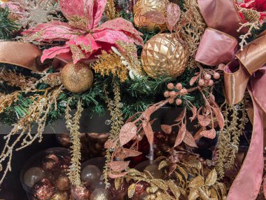 Süsler, çiçek aksanları ve dekoratif kurdele içeren zarif bir tatil düzenlemesi.