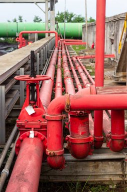 Endüstriyel boru hattı sisteminin ayrıntılı bir görüntüsü, modern tesisler ve modern tesisler için gerekli karmaşık mühendislik ve altyapıyı vurgulayan karmaşık bir kırmızı boru ve valf ağını ortaya çıkardı.