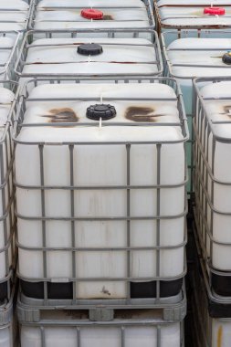 Bu resim, büyük miktarlarda sıvı ve malzeme depolama ve taşımacılığında kullanılan istiflenmiş bir grup IBC 'yi gösteriyor. Bu konteynırlar depolama, dağıtım ve lojistik için verimlidir.