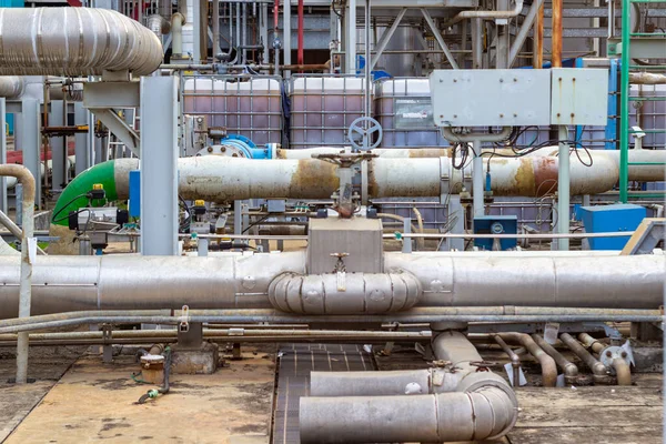 Görüntü, bir işleme tesisi içindeki karmaşık bir endüstriyel boru hatları ve ekipman ağını tasvir ediyor. Bu detaylı görünüm, bu gibi tesislerdeki mühendislik ve inşaatı gösteriyor,