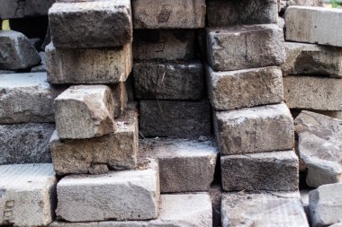 Yıpranmış ve yığılmış gri tuğla blokların kaba bir duvar oluşturduğu kırsal doku. Yapı, mimari veya soyut tasarımlar için ideal, eski materyallerin ve sağlam yapıların vurgulanması