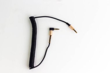 Sade beyaz bir yüzey üzerinde altın kaplama kablolu siyah bir kablo görülür. Bu da cihazları klasik bir hisle bağlamak için ses veya elektronik bir bileşen olduğunu gösterir.