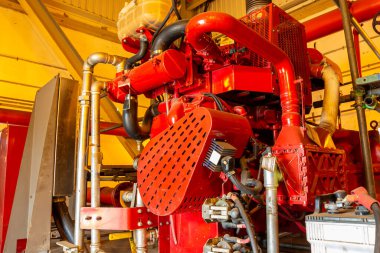 Yakın plan, boruları, hortumları ve diğer mekanik aletleri olan güçlü bir endüstriyel jeneratör gösteriyor.