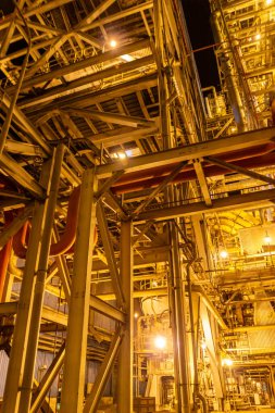 Geceleri sanayi kompleksi parlak ışıklarla aydınlatılmış rafineri yapısını gösteriyor..
