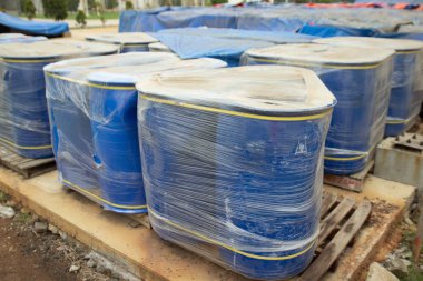 Plastik filme sarılı mavi konteynırlar dışarıda ahşap paletlerde sevkiyatı bekliyor.