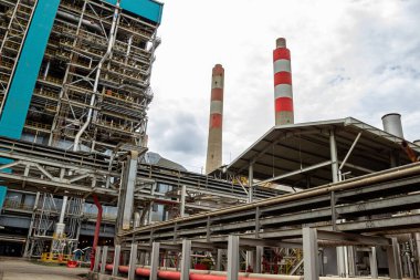 Karmaşık çelik yapılara ve yüksek kırmızı çizgili bacalara sahip endüstriyel fabrikalar