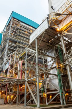 Karanlık çöktüğünde kompleks boru ve metal yapısına sahip büyük endüstriyel fabrikanın dış görünüşü