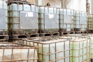 Yığılmış orta büyüklükteki konteynırlar sıvı tutuyorlar, paletlerin üzerinde oturuyorlar, sanayi bölgesi.