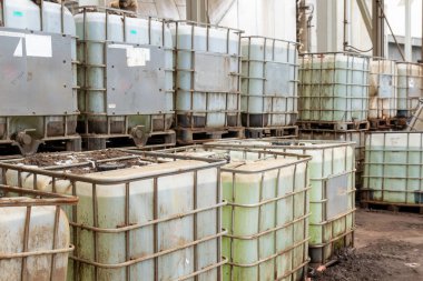 Endüstriyel alanda sıvı kimyasallar depolayan orta büyüklükteki konteynırlar..