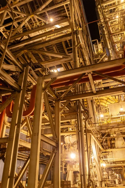 Endüstriyel kompleks kirişler ve borular rafineri tesisinde gece ışığını yansıtıyor