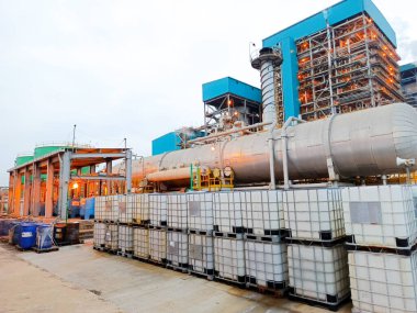 Bu görüntü, karmaşık altyapısı ve depolama tesisleri olan bir enerji santralini gece vakti ortaya çıkaran bir endüstriyel tesisi yakalıyor. Sahne, enerji üretim sürecini tanklarla gösteriyor.