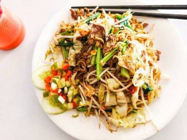 Etli, lahanalı, sebzeli ve salatalıklı lezzetli Asya usulü kızarmış şehriye.