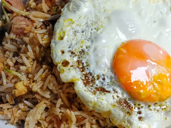 Bu fotoğraf, iyi hazırlanmış bir tabak pilavın güneşli tarafı kızarmış yumurtayla görsel çekiciliğini yakalar. Yiyeceğin canlı renkleri ve dokuları iştah açıcı bir görüntü oluşturuyor. Bu...