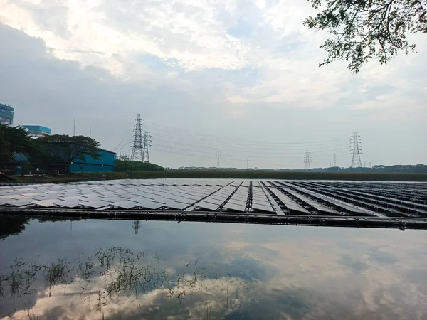 Suda yüzen güneş enerjisi istasyonu yenilenebilir enerji kaynakları üretiyor, gökyüzünü ve panelleri yansıtıyor ve çevresel koruma, yenilikçi yenilenebilir enerji teknolojisine katkıda bulunuyor.,