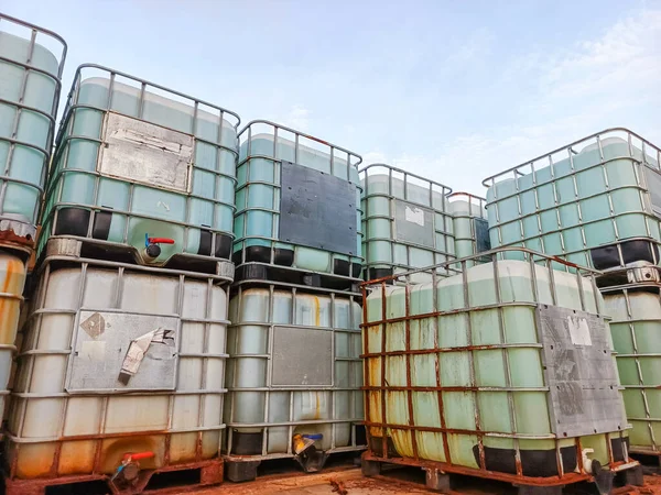 Paletlerin üzerine istiflenmiş sanayi konteynırları gün ışığı atmosferi olan açık gökyüzü altında üretim veya ticari bir ortamda malzeme işleme ve depolama manzarası sunuyor.