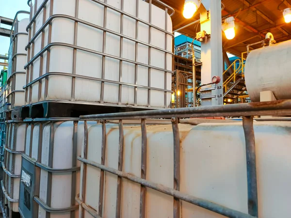 Bir grup endüstriyel konteynır bir depolama tesisine istiflenmiş. IBC plastik ve metalden yapılmıştır. Sıvı maddeler için fabrika içi ağır iş kutuları.