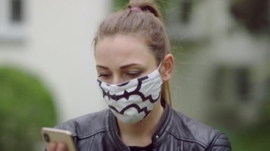 Maskeli genç bir kadın telefonda konuşuyor..