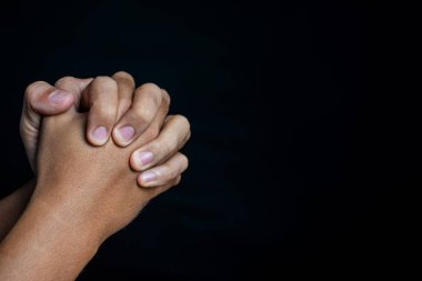 Erkek eli, siyah arka planda izole edilmiş bir hareketi över ya da ibadet eder. din ve maneviyat kavramı