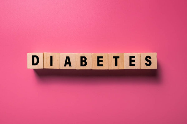слово диабет на деревянных блоков изолированы на розовом фоне