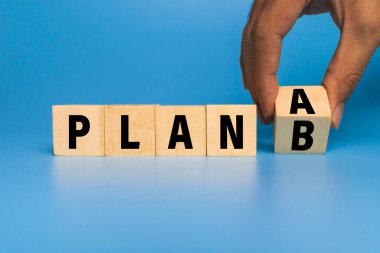 A ya da B planı mavi arka planda izole edilmiş tahta blokları çevirin. İş stratejisi planlama kavramı