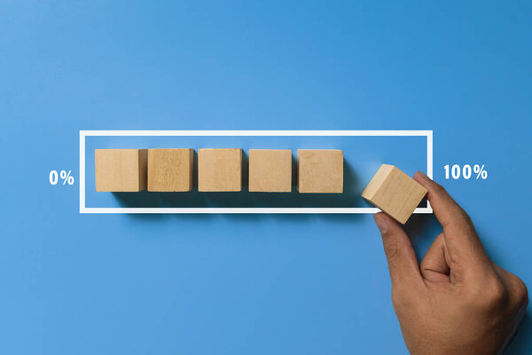 male hand put wooden blocks in loading screen isolated on blue background. progress concept