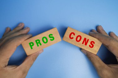 Erkek eller artı ve eksileri tutuyor. Ahşap bloklar mavi arka planda izole edilmiş.