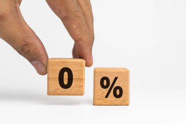 Erkek eli, beyaz arka planda izole edilmiş tahta bloklara yüzde sıfır harf sembolü koyuyor. ticari finansal konsept
