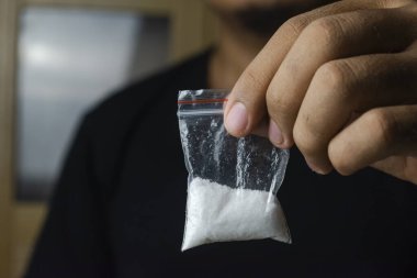 Uyuşturucuyla el ele tutuşan bir adamın resmi. Uyuşturucu bağımlısı bir adam konsepti. Uyuşturucuyu durdur