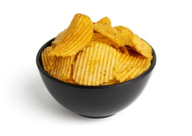 Beyaz arka planda izole edilmiş siyah kasede sarı patates cipsi.