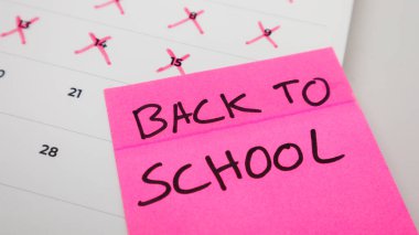 A pink sticky note with 