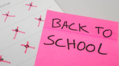 A pink sticky note with 