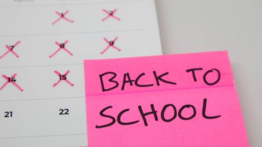 A pink sticky note with 