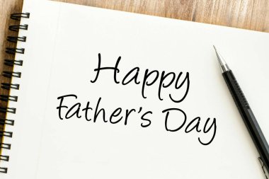 Yürekten mutlu babalar günü mesajı. Sarmal bir deftere bir kalemle kibarca yazılmış. Babalara şükranlarını sunmak için birebir.