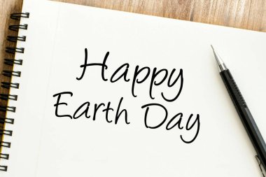 Spiral bir not defterine yazılmış, gelecek nesiller için çevresel bakımı ve küresel sürdürülebilirliği destekleyen içten bir Mutlu Dünya Günü mesajı.