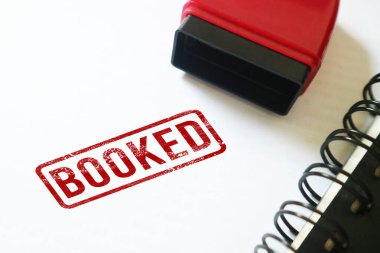 Beyaz bir deftere kırmızı damga yapıştırılmış.