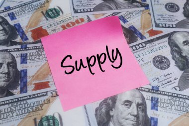 Üzerinde Amerikan dolarları olan pembe yapışkan bir not. Piyasa envanteri, ekonomi ve kaynaklar kavramı.