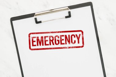 Beyaz kağıt panoda kırmızı acil durum damgası.