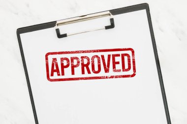 Beyaz kağıt panoda kırmızı onaylı kauçuk damga.