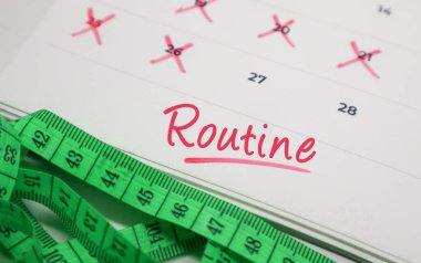 Takvimde ölçü bandıyla rutin metin. Günlük alışkanlık, fitness hedefleri ve sağlık izleme kavramı.