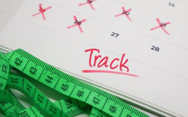 Takvimdeki metni mezura ile birlikte izle. Sağlık izleme, fitness hedefleri ve ilerleme verileri kavramı.