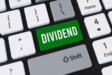 Hisse yatırımı için DIVIDEND yazan beyaz metinli belirgin yeşil bir anahtar içeren bir bilgisayar klavyesinin yakın plan görüntüsü.
