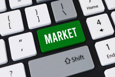 Hisse senedi ticareti ve küresel ticaret için MARKET yazan yeşil anahtar ve beyaz metni olan bir bilgisayar klavyesinin yakın plan görüntüsü.