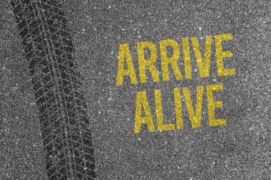 Asfalt zeminde sarı metinli lastik izi var. Yol güvenliği ve trafik farkındalığı kavramı.