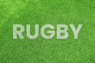 RuGBY kelimesi canlı yeşil çimen arka planında beyaz dokulu metinlerle boyandı. Spor sahası sahası konsepti.
